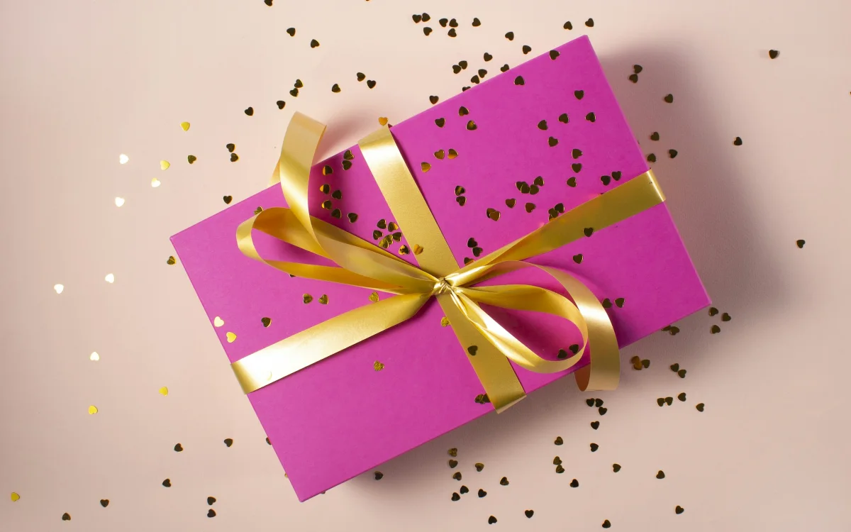 A wrapped gift box with a gold ribbon — Joyology Rewards